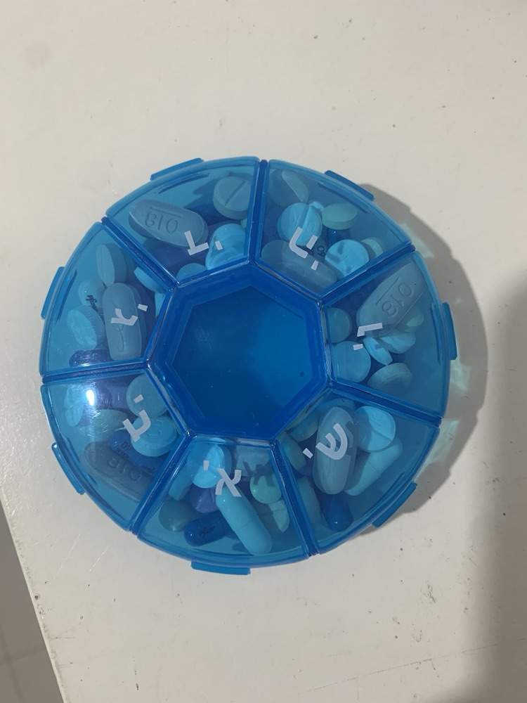 Round blue weekly pill organiser with a turning lid