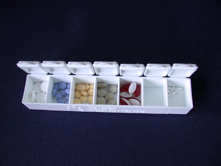 White seven-day pill box on a dark background
